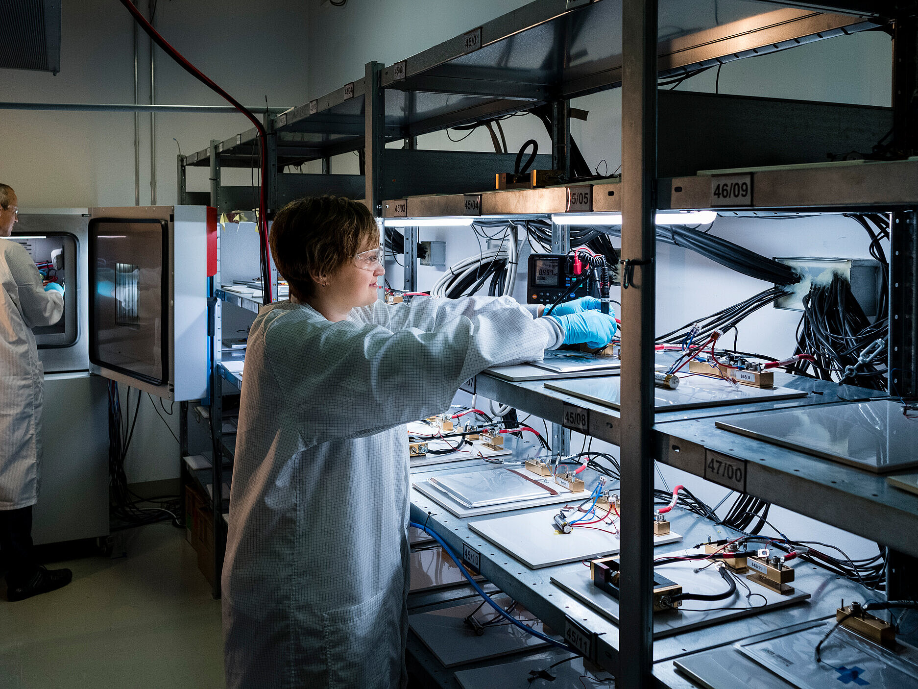 Wissenschaftlerin im Zelltestlabor des KIT arbeitet an einem Laborgerät mit mehreren Proben und elektronischen Komponenten.