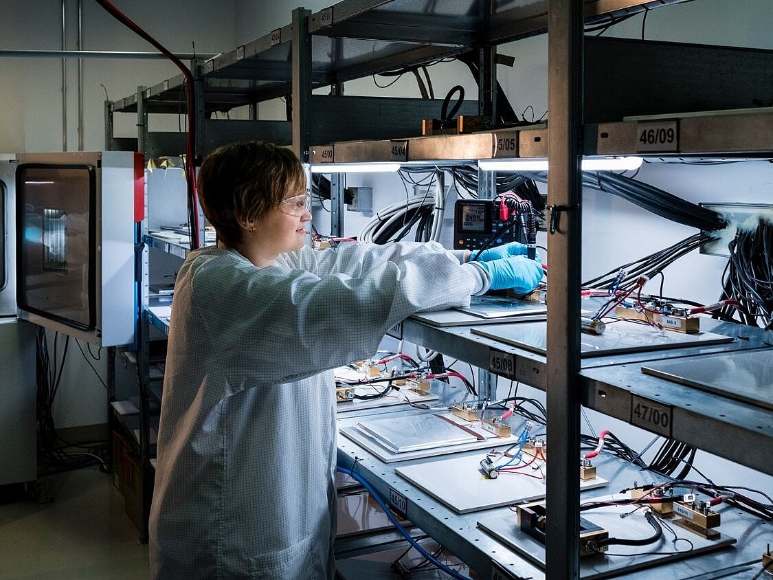 Wissenschaftlerin im Zelltestlabor des KIT arbeitet an einem Laborgerät mit mehreren Proben und elektronischen Komponenten.
